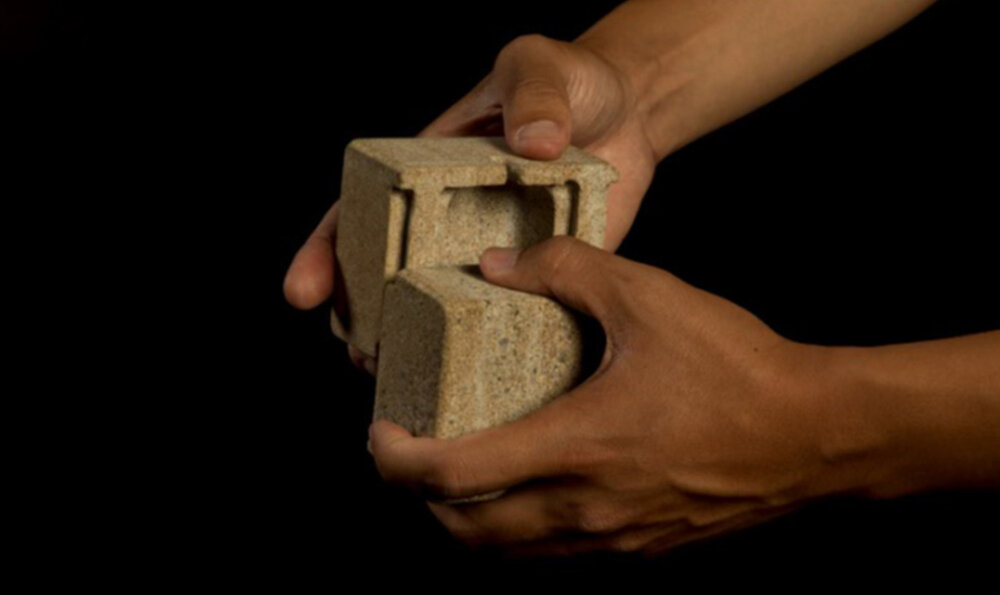 Two hands fitting two small pieces of ceramic together to form a box
