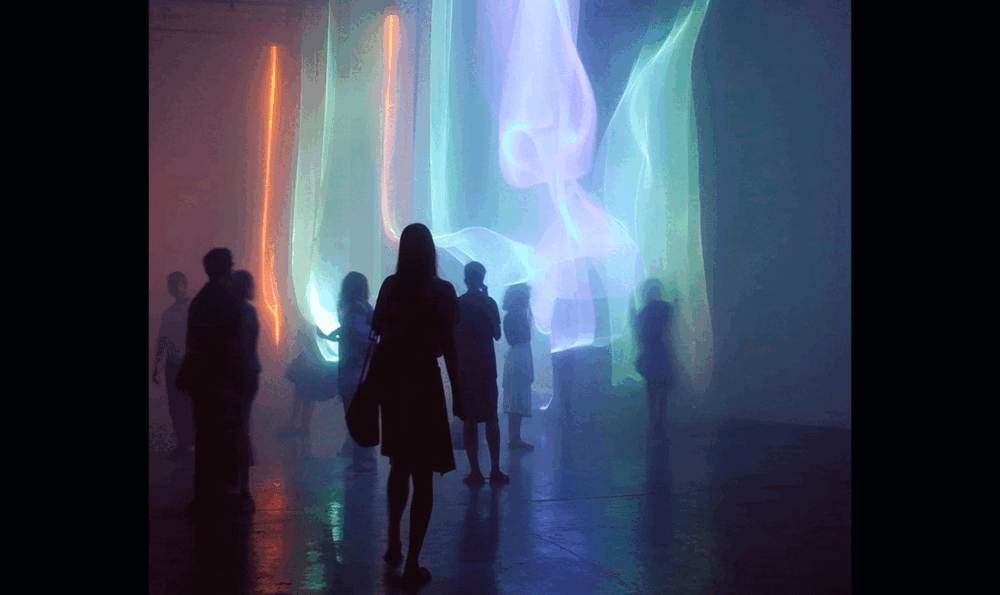 Visitors at an interactive installation with halos of light in the background