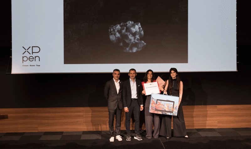 The management and academic staff of IED Barcelona presenting a tablet on stage to the student winner of the Best Thesis in Visual Arts at IED Barcelona.