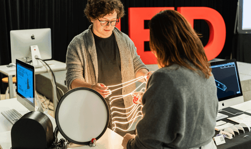 A young man showing a girl an LED necklace