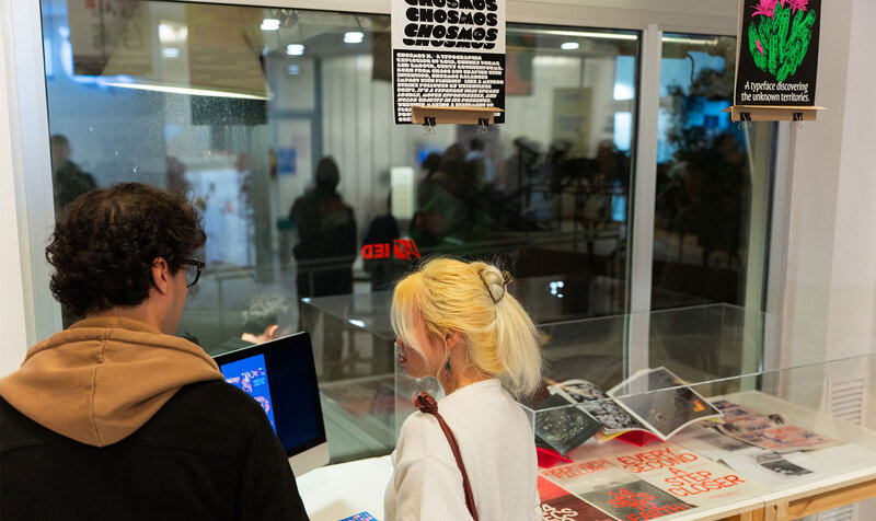 People at a typography exhibition looking at a display case