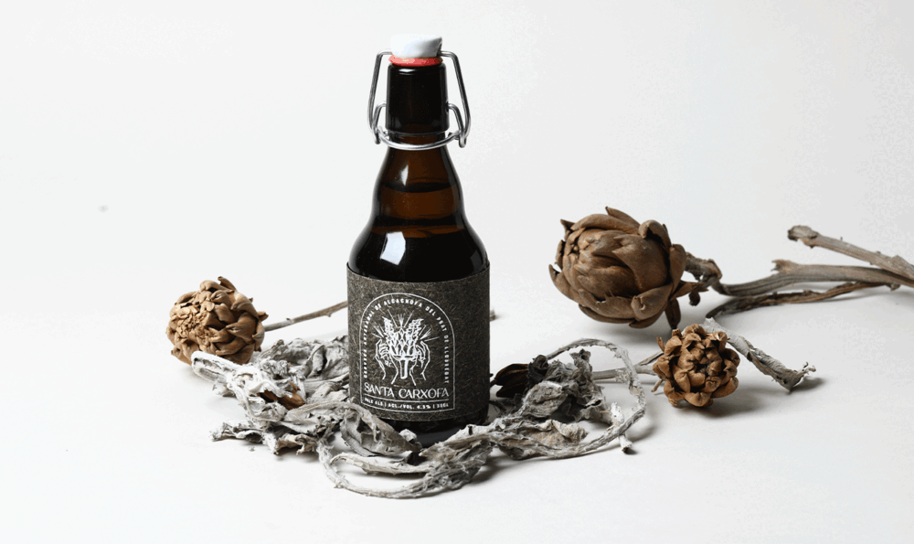 A bottle of craft beer next to dried artichoke waste