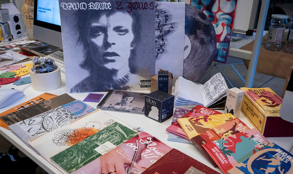 A table with various posters and images from graphic design campaigns
