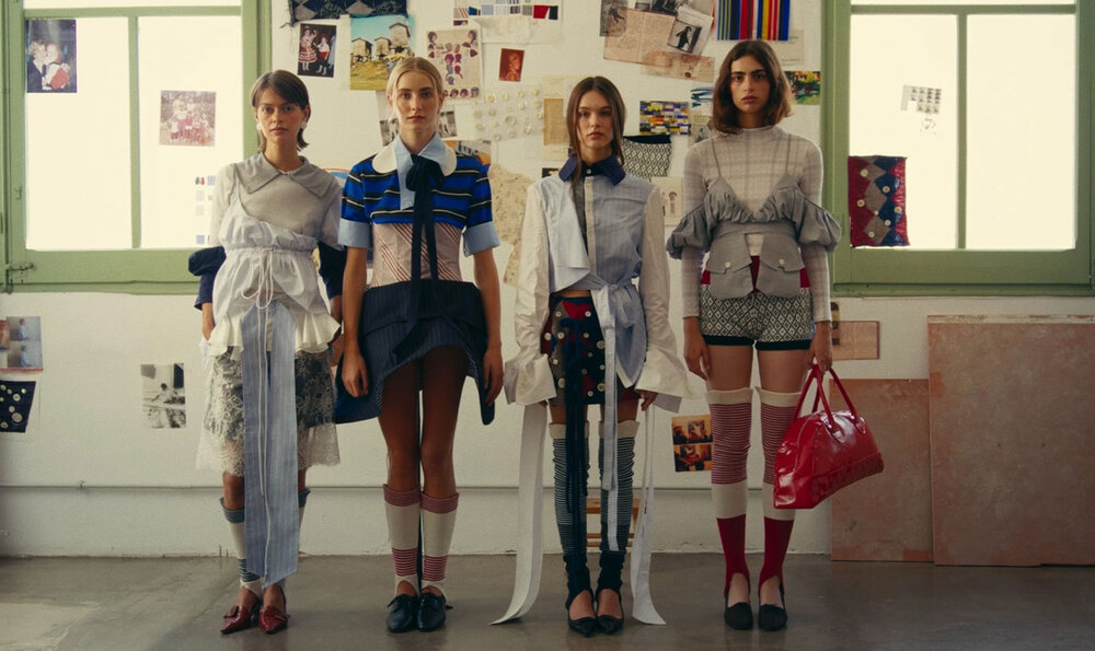 Four models posing in a classroom